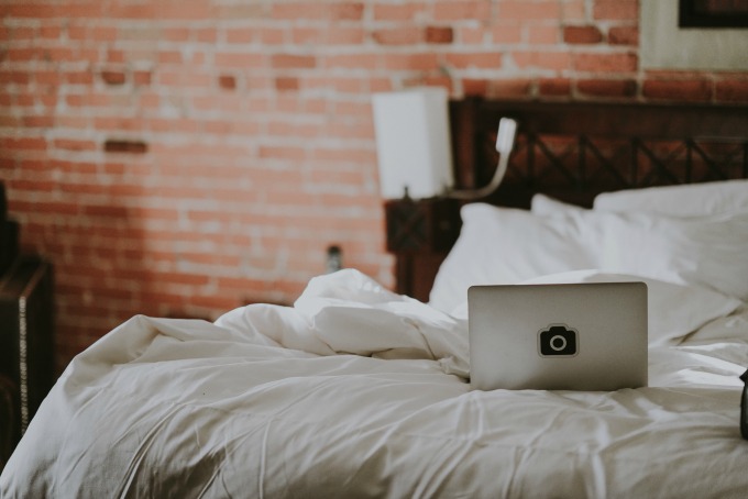 Laptop on a bed in a brick loft