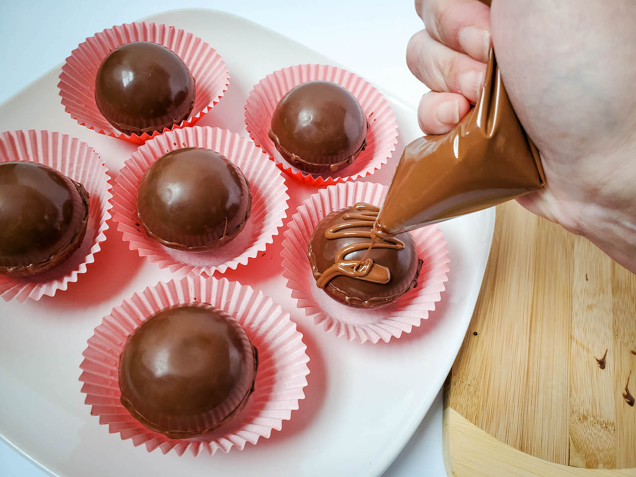 process shot - chocolate being drizzled on top of chocolate balls