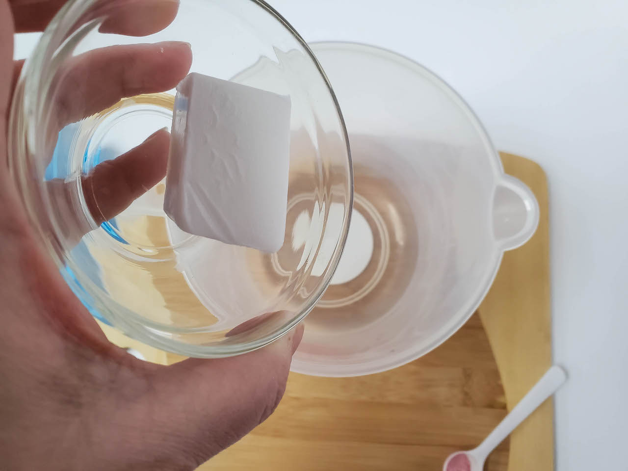 soap base being placed in a measuring cup