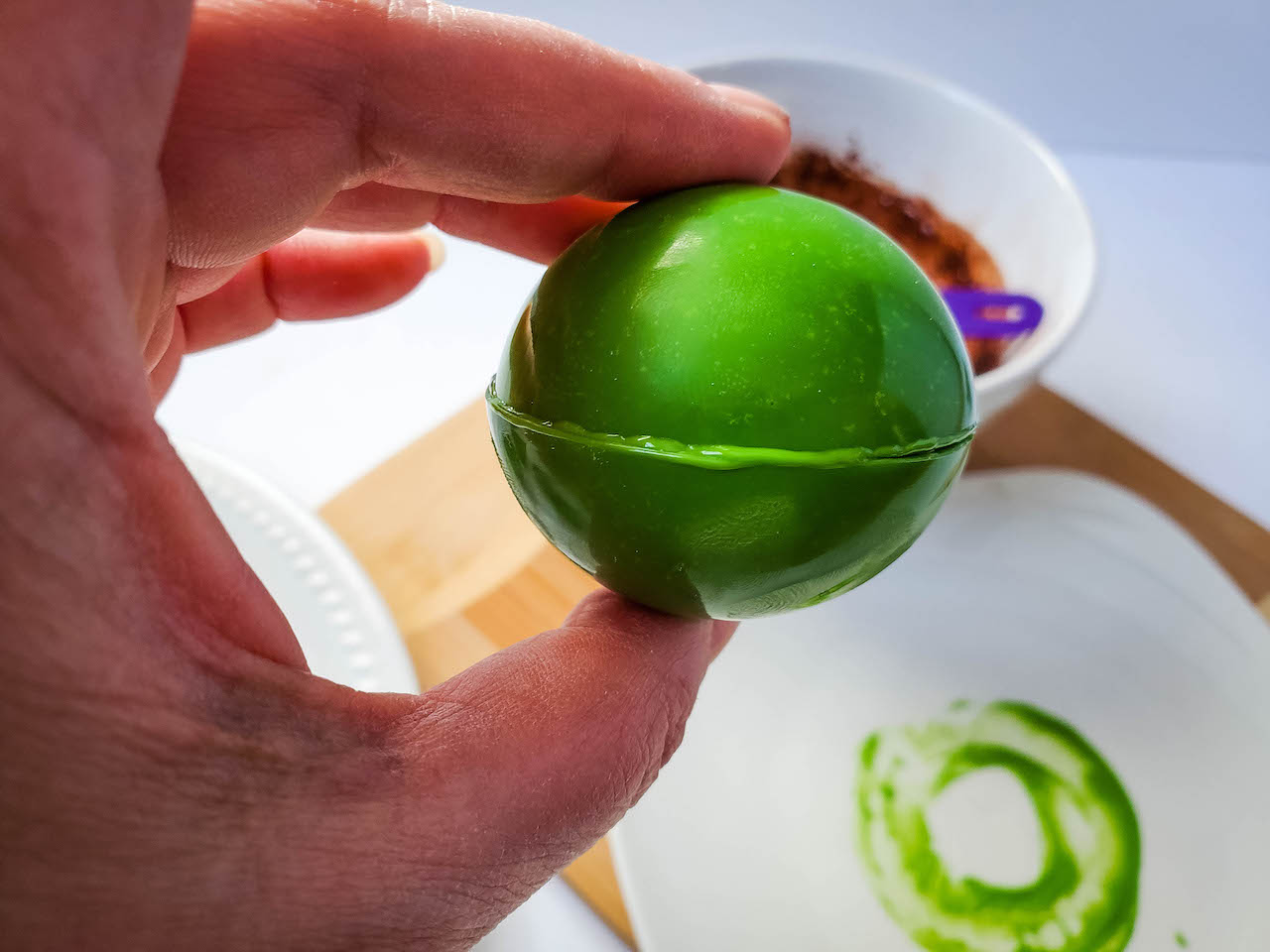 two green spheres being sealed together for chocolate bomb