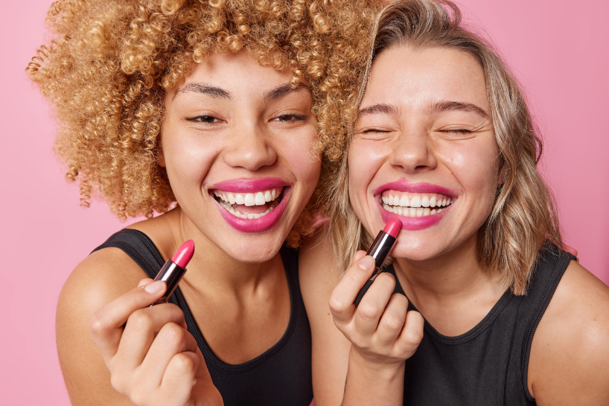 Two young women with bright pink lipstick