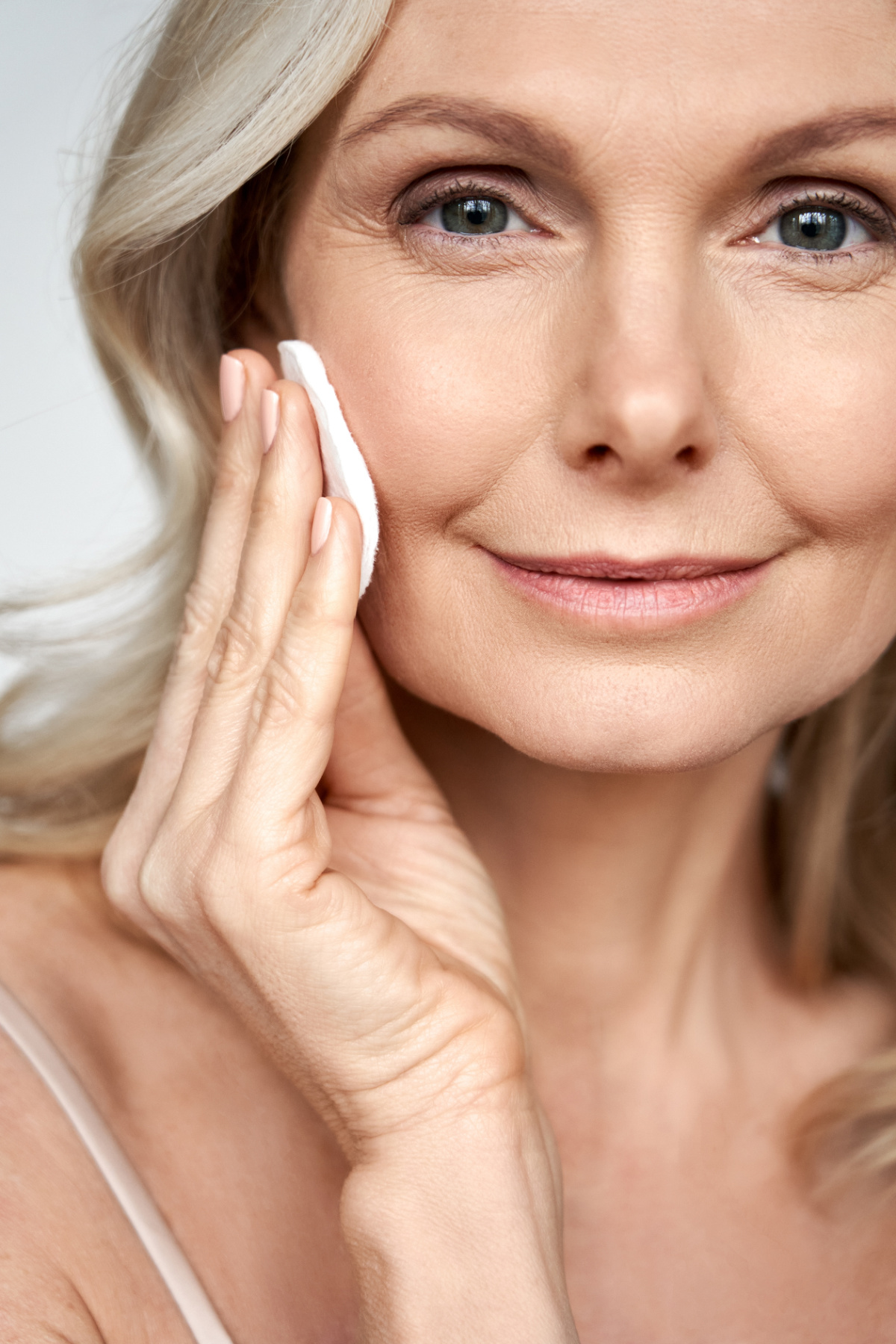 woman with a cotton pad performing skincare