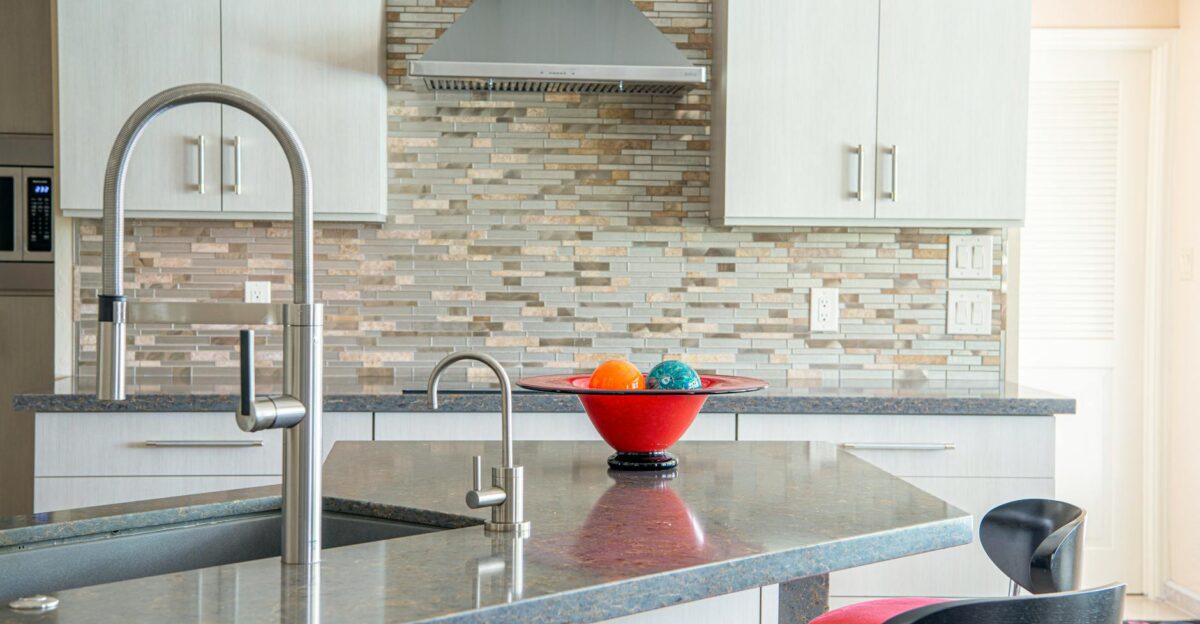Contemporary kitchen interior with a sleek faucet and colorful fruit bowl on granite countertop