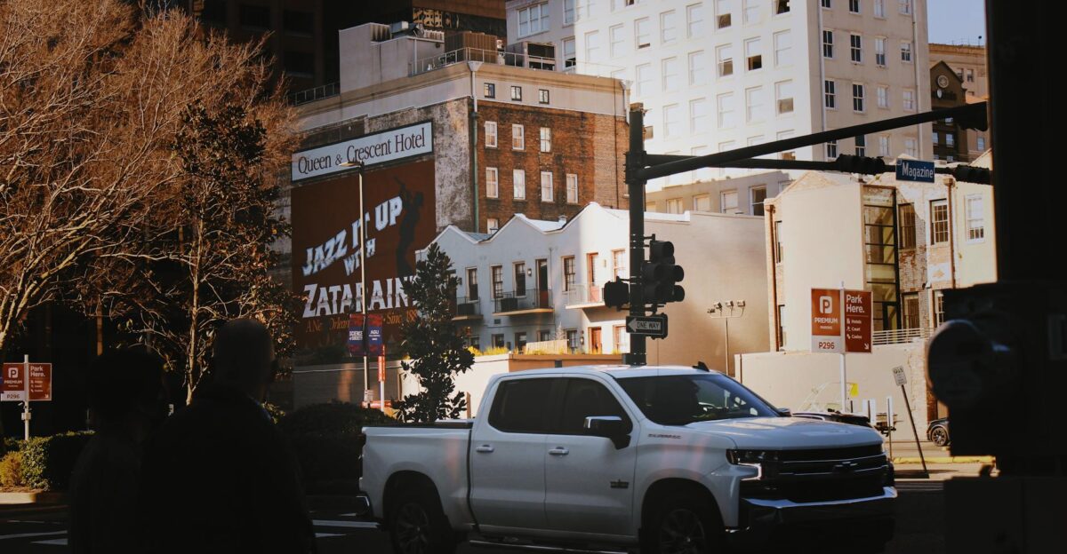Side view of a parked white pickup truck on a New Orleans street during the day