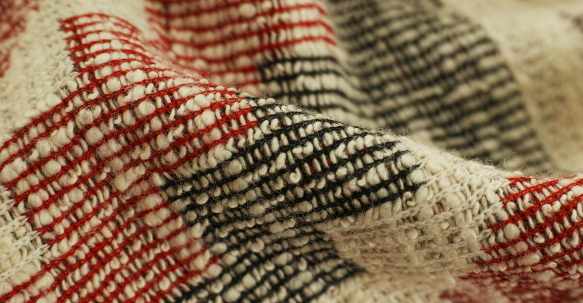 Detailed view of a red and black checked handwoven textile showcasing texture and craftsmanship