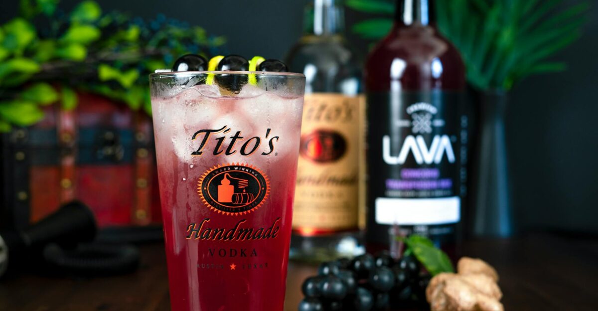 A vibrant berry cocktail featuring Tito's Handmade Vodka, garnished with grapes.