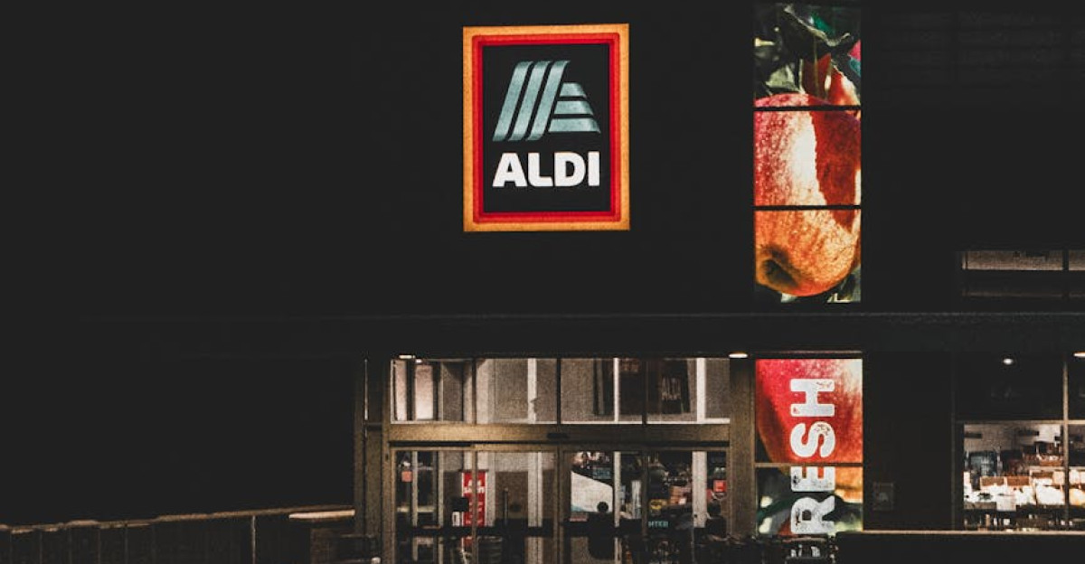 A nighttime winter view of an Aldi storefront with a prominent logo captured in Roeland Park KS