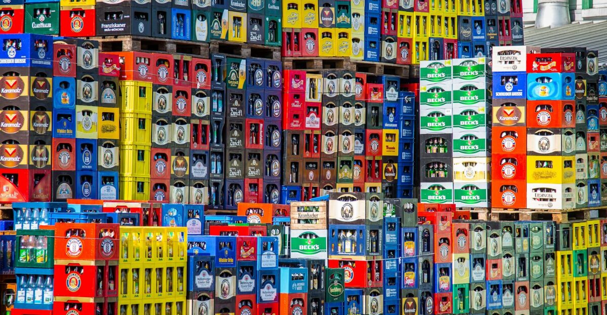 A vibrant display of beer crates stacked in a warehouse, showcasing various brands.