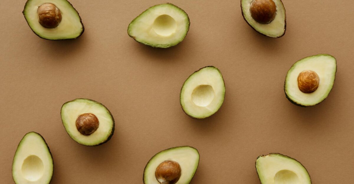 Aesthetic flat lay of ripe avocado halves arranged on a warm brown surface showcasing freshness and healthy eating