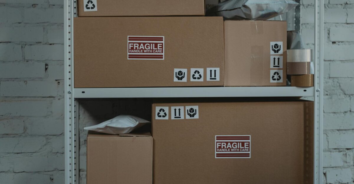 Cardboard boxes labeled 'Fragile' stacked on metal shelving in a storage room.