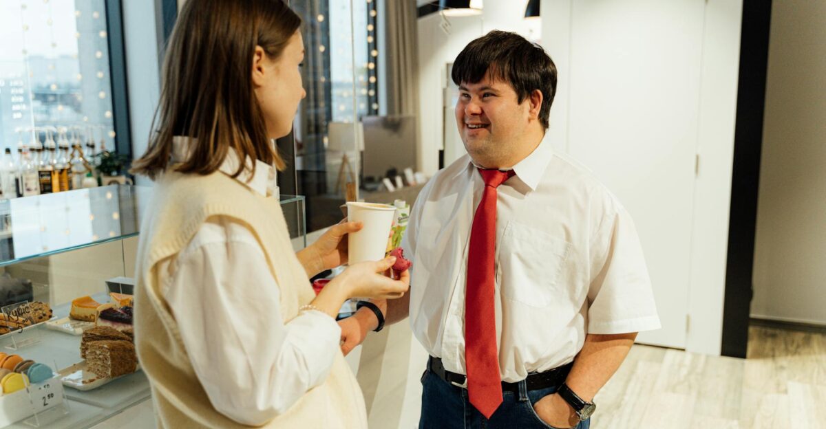 Professional staff and customer engaging in warm conversation inside a contemporary café.