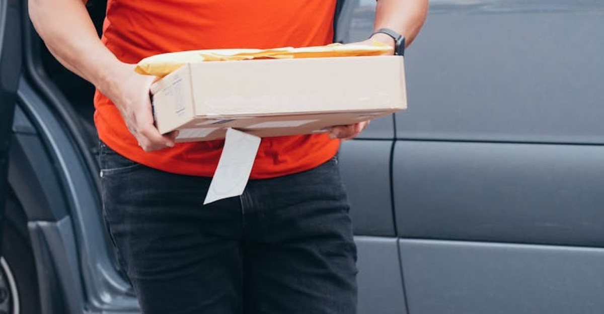 Smiling courier delivering a package from a van showcasing reliable delivery service