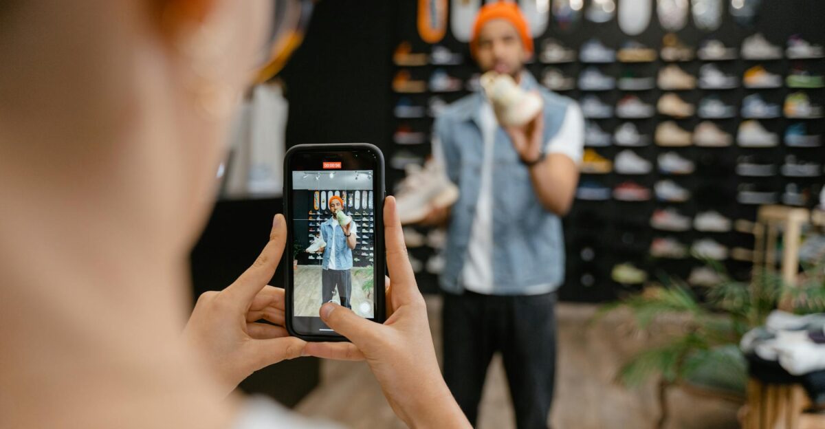 Person filming a shoe shopping experience in a trendy store using a smartphone