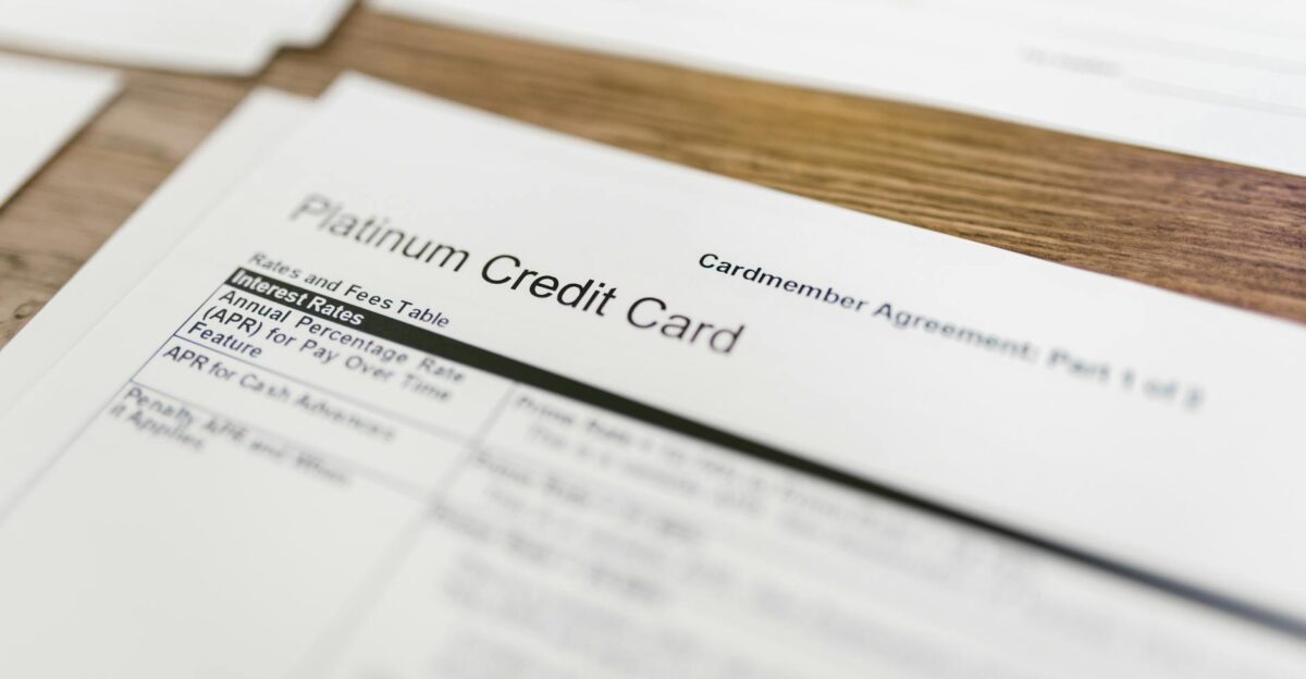 Close-up of a platinum credit card agreement document on a wooden desk