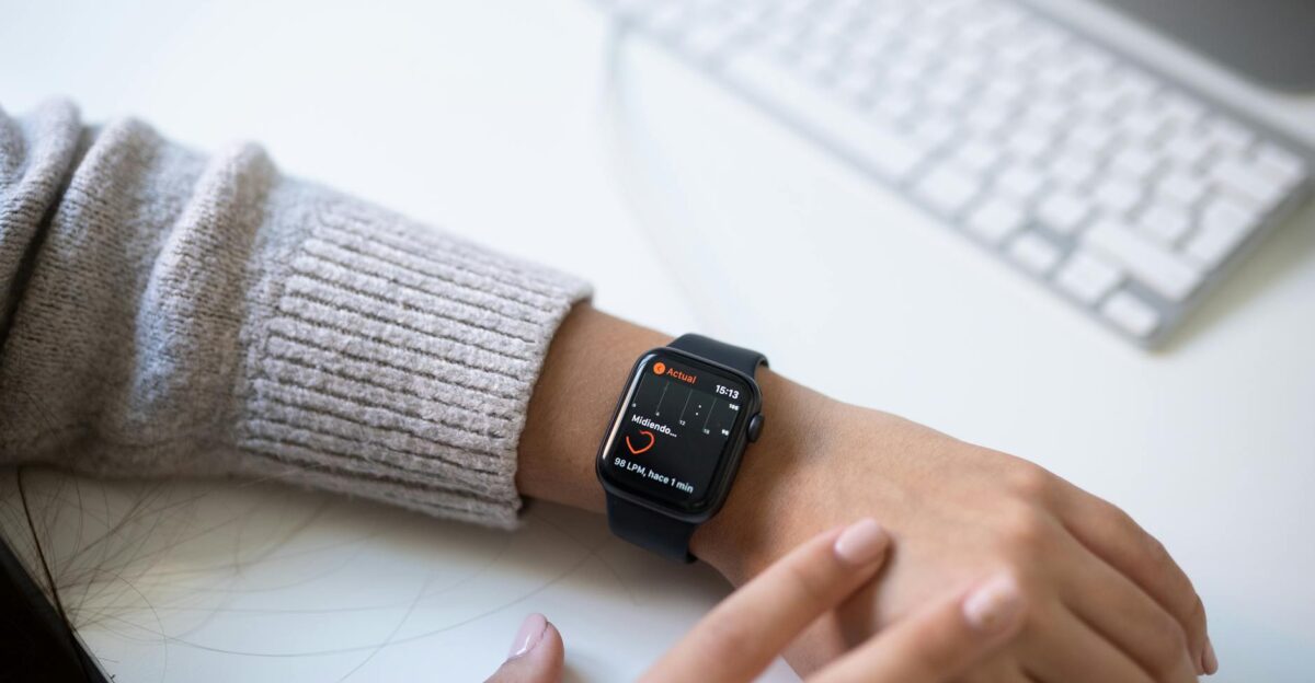 Close-up of a person checking health stats on a smartwatch in an office environment