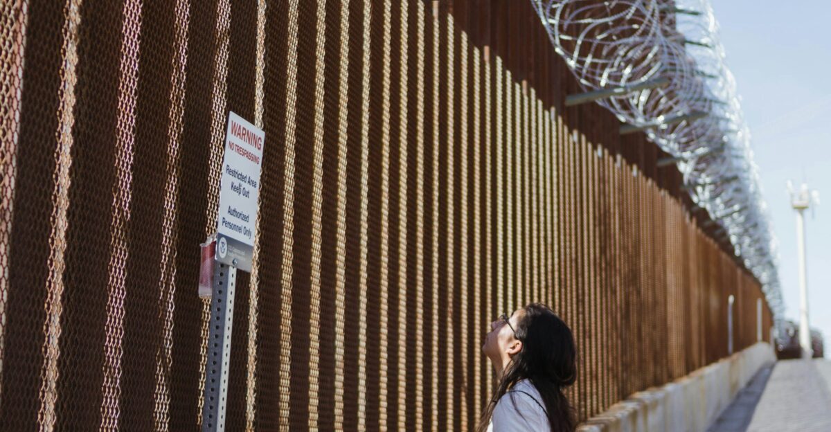 woman in white shirt standing on brown wooden bridge during daytime