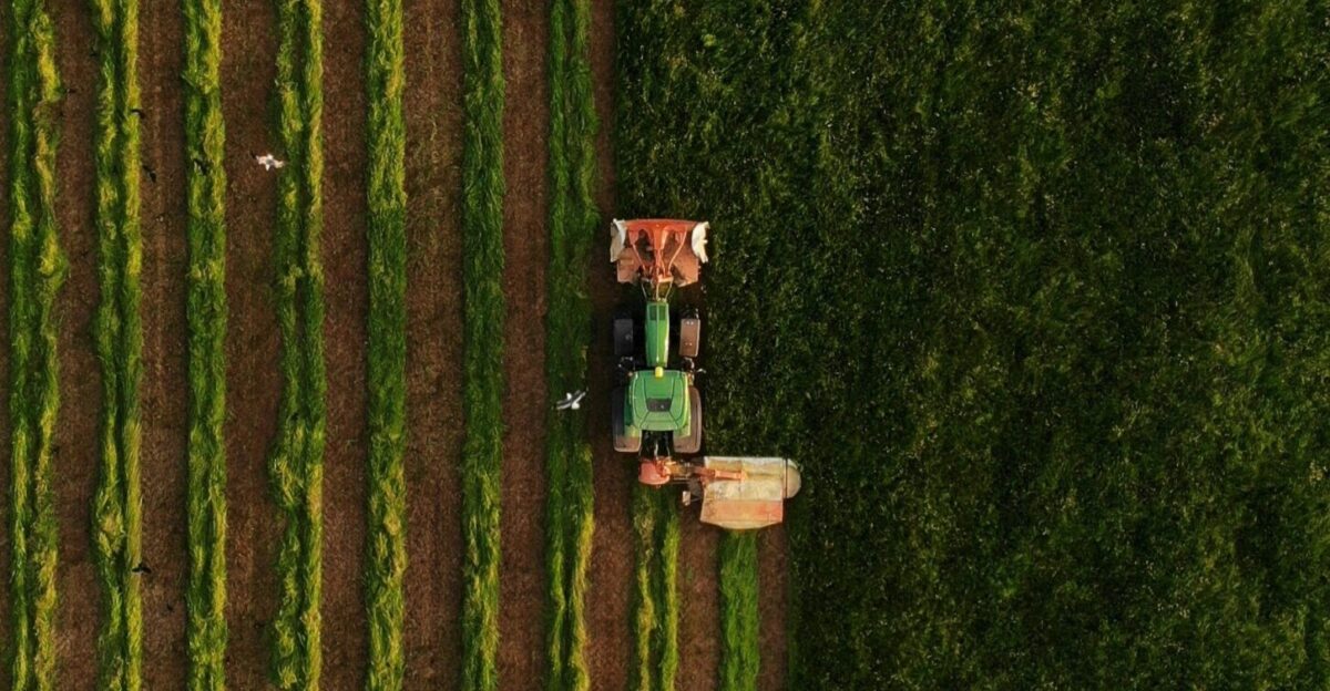 an aerial view of a tractor plowing a field