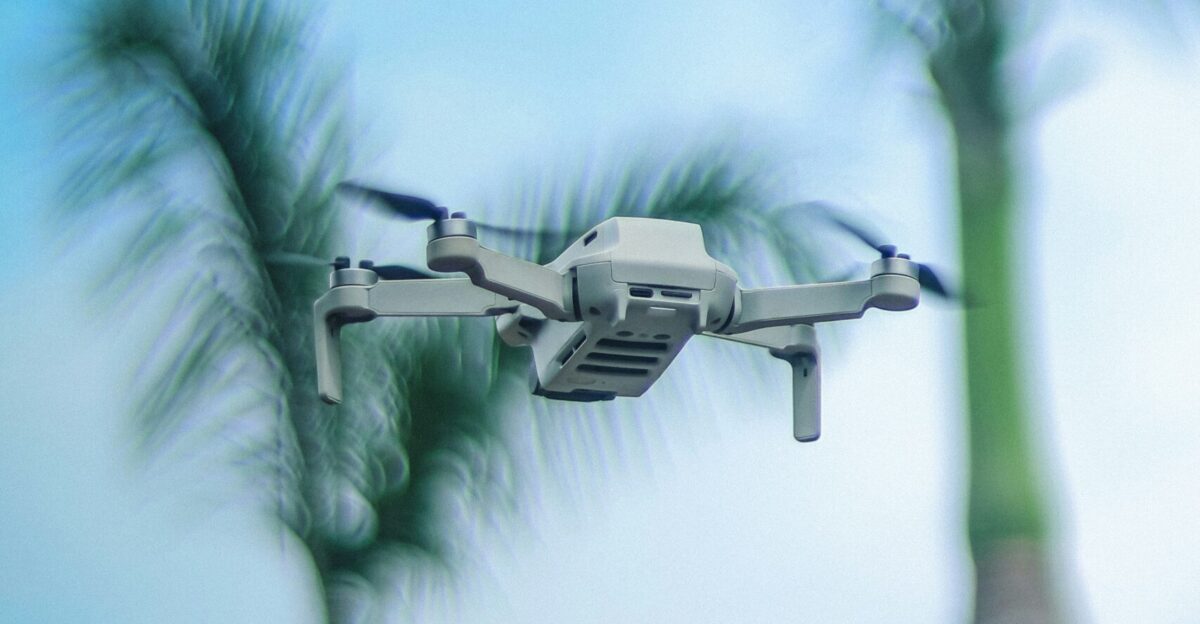 a camera attached to a remote control system flying over a palm tree