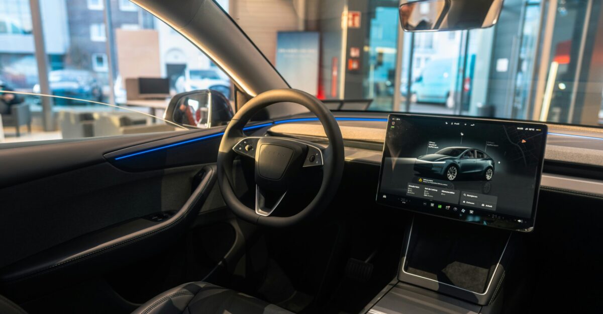The interior of a car with a laptop on the dashboard