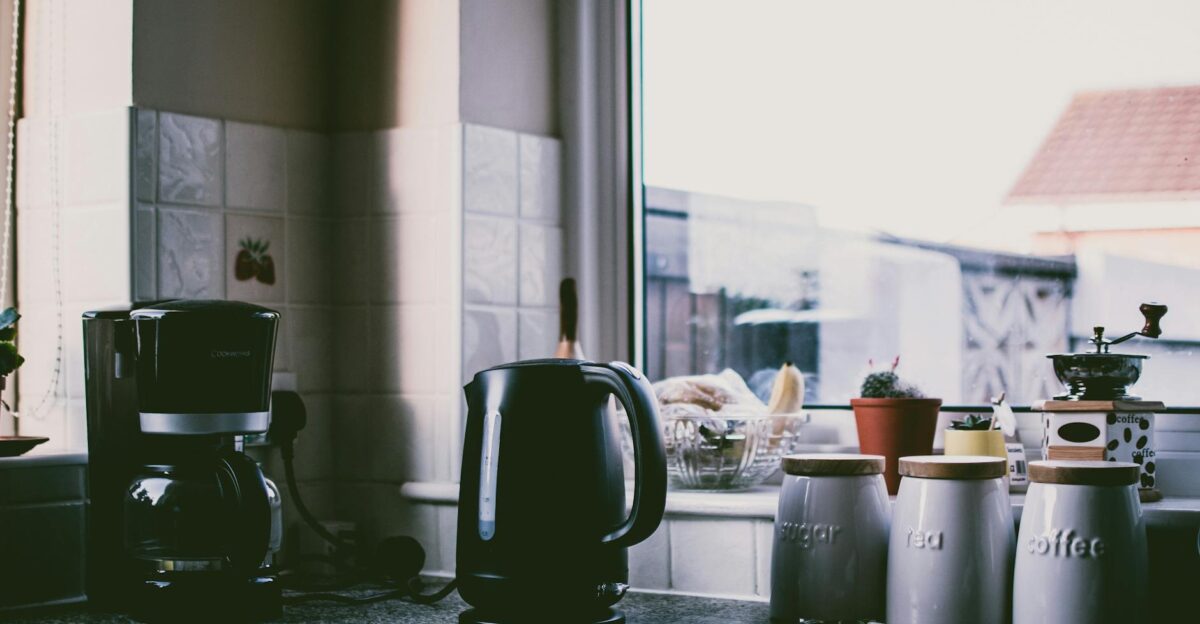 Cozy kitchen scene with coffee maker kettle and jars on a sunny counter
