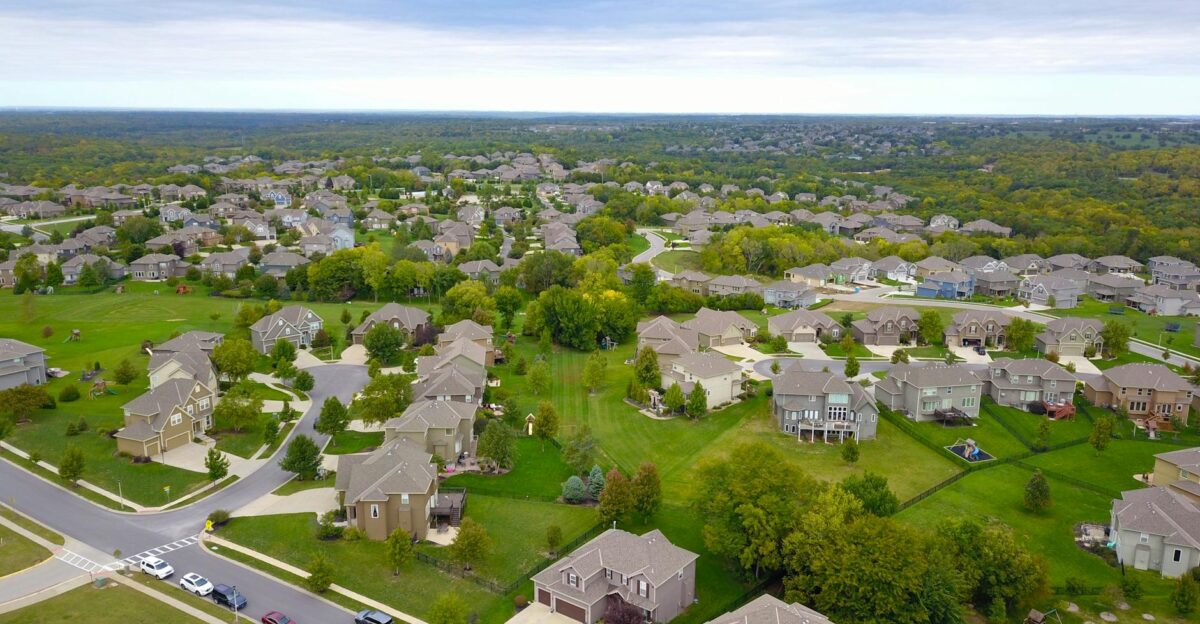 Aerial view of a suburban neighborhood with houses roads and lush greenery