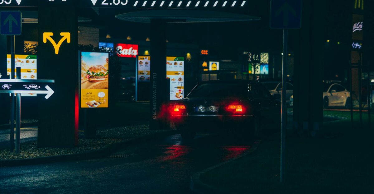 Car navigating a McDonald s drive-thru at night showcasing urban dining atmosphere