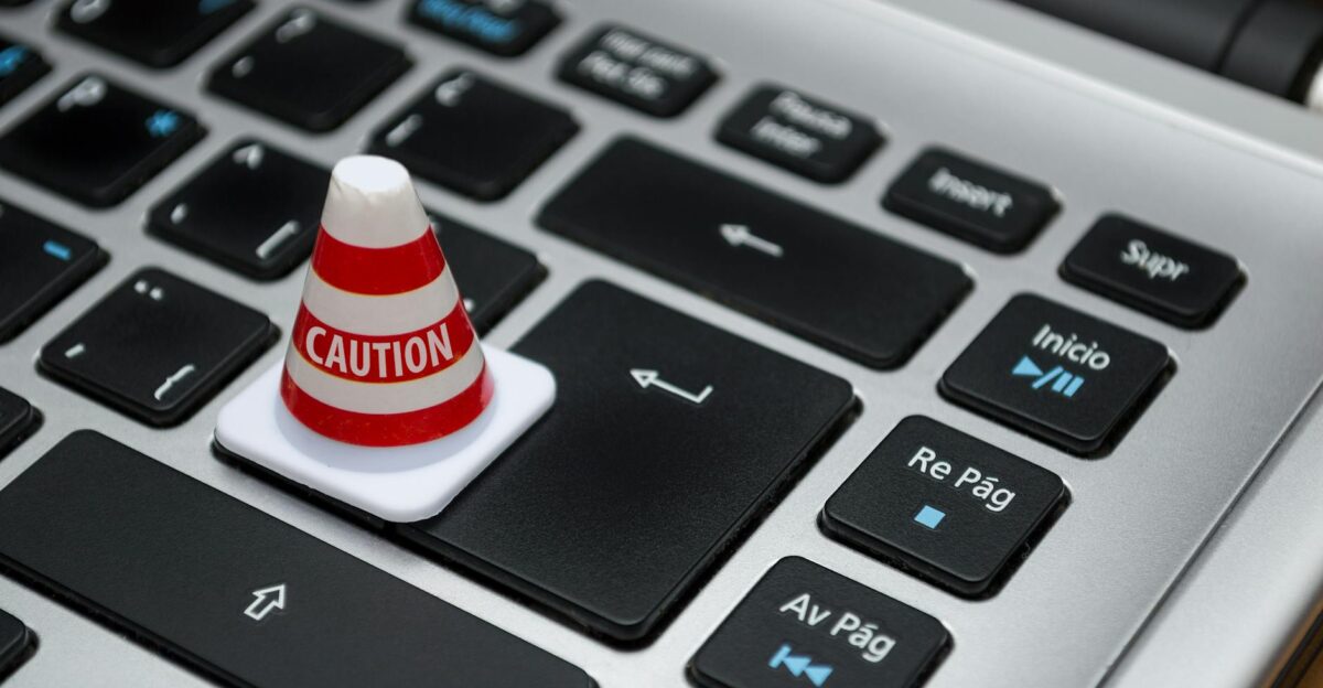 Miniature caution cone on a computer keyboard symbolizing data security and control