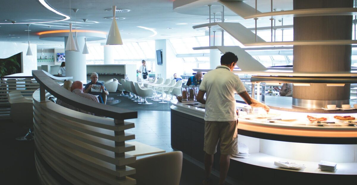 Stylish airport lounge with buffet and seating featuring sleek interior design and contemporary furniture