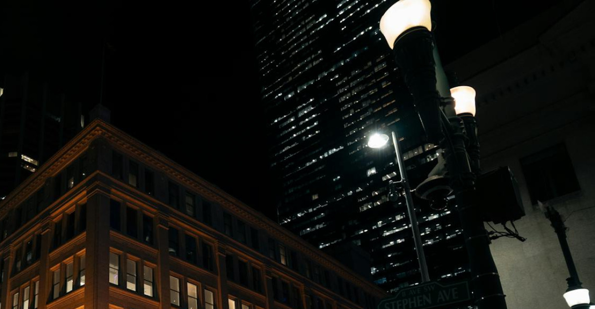 Illuminated Hudson s Bay building at night in bustling urban setting with pedestrians