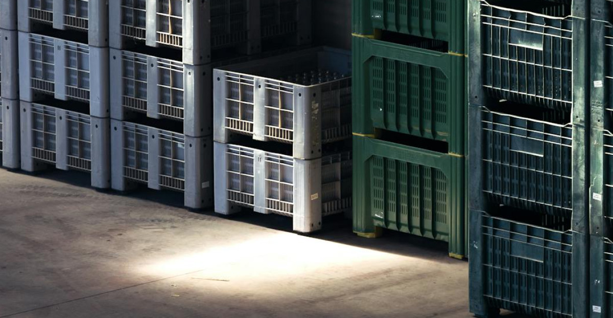 Sunlight streaming onto stacked crates in a warehouse creating contrasting shadows and highlights