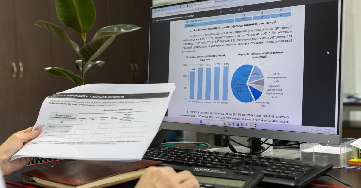 Person analyzing financial data on a computer screen in an office setting