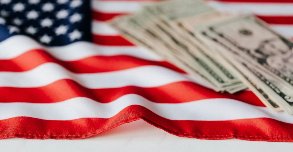 Close-up of American flag with US dollar bills symbolizing economy and patriotism