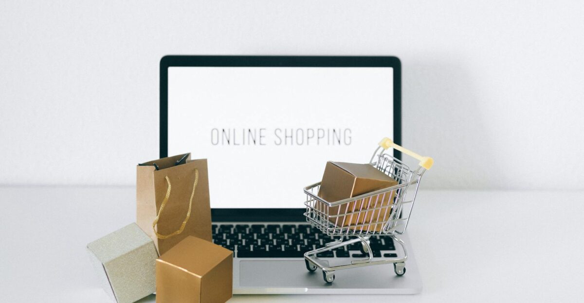 Laptop displaying online shopping with boxes and cart representing ecommerce
