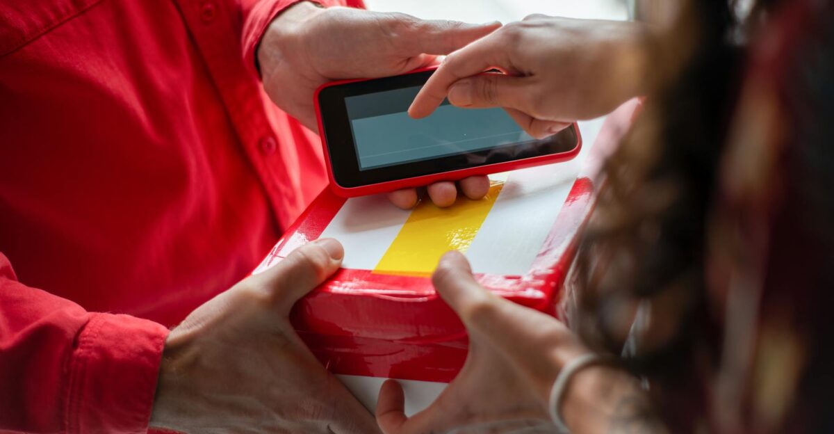 Hands exchanging a package with an electronic signature for contactless delivery