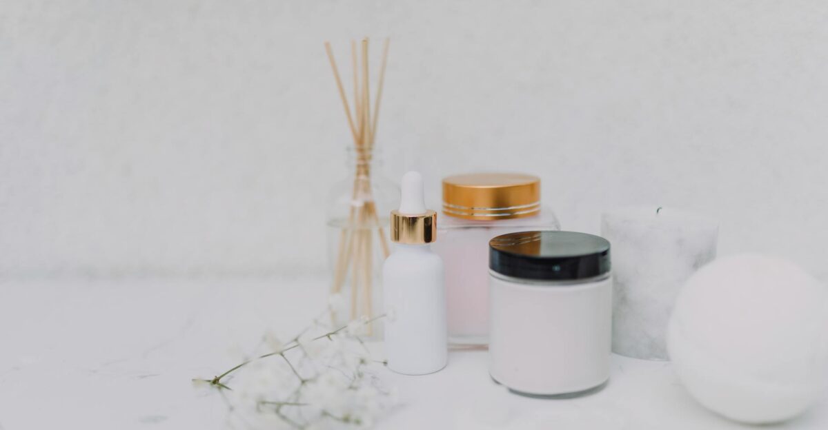 Elegant minimalistic display of skincare products and aromatherapy essentials on a clean white background
