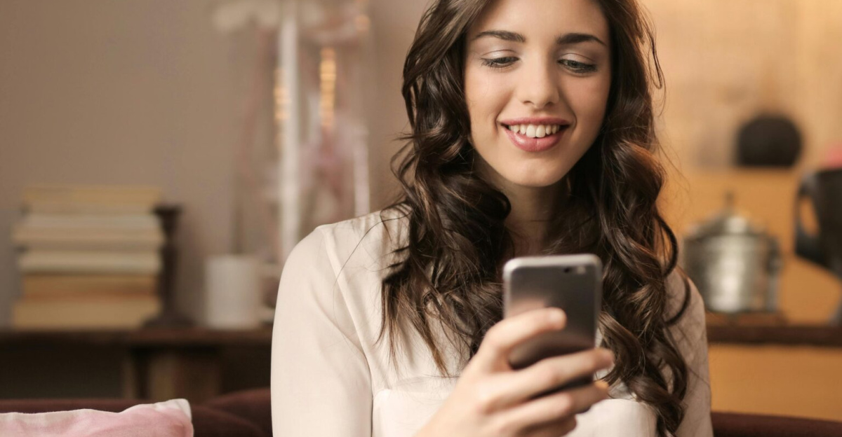 A woman enjoying leisure time using her smartphone and laptop in a cozy living room.