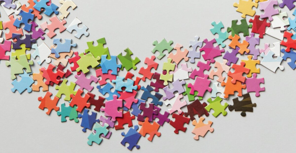 Vibrant jigsaw puzzle pieces scattered on a clean white background Perfect for creativity concepts