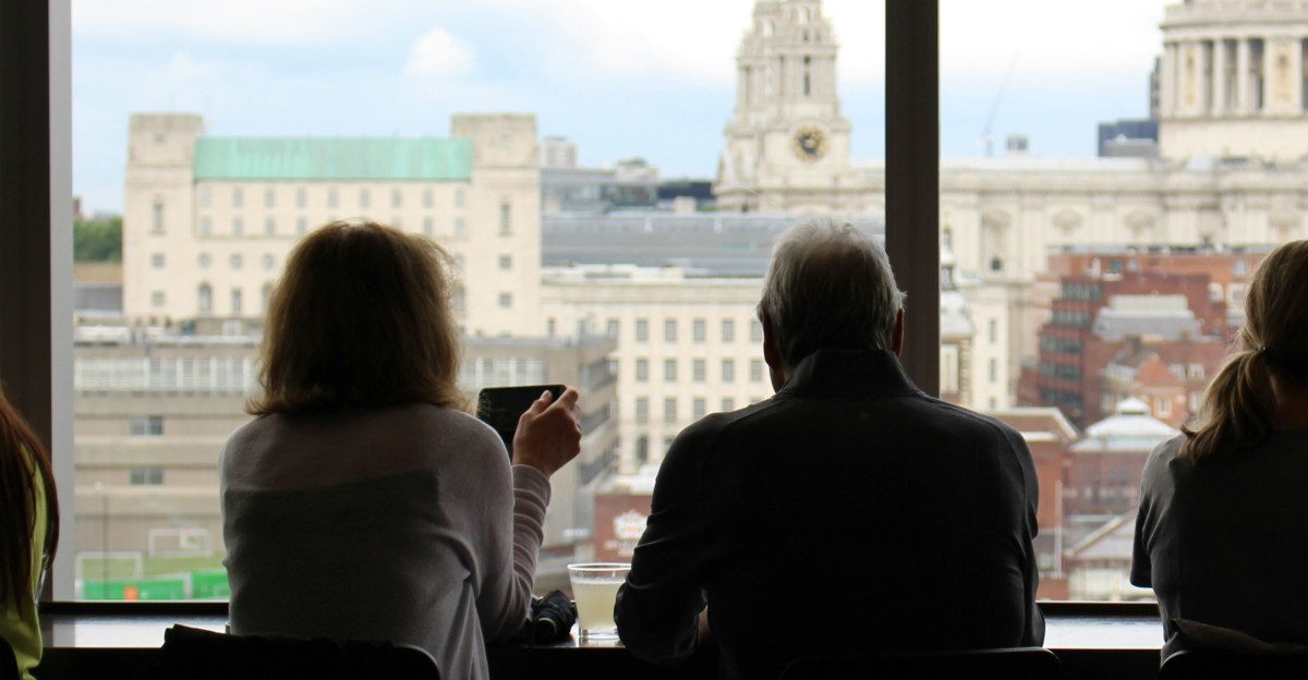man in between of four women sits while watching on window