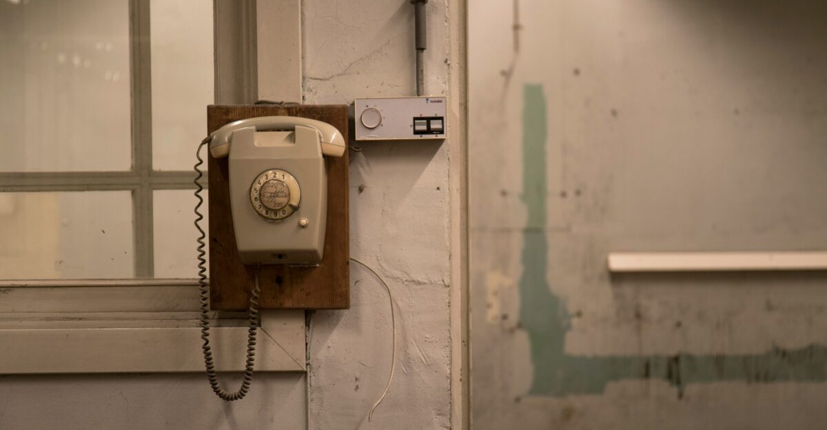 an old phone is hanging on a wall