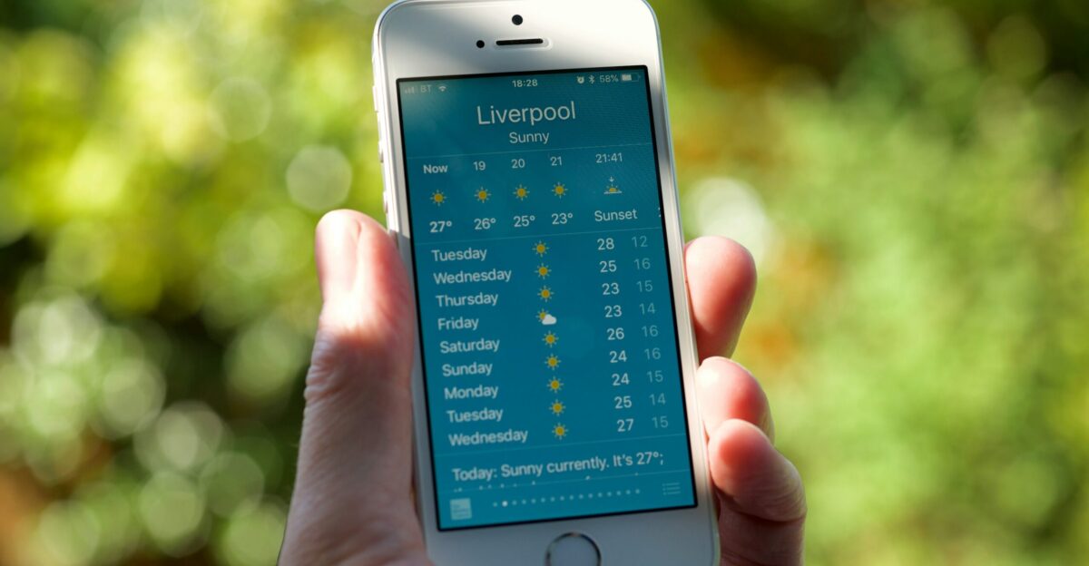 person holding turned on silver iPhone 5s displaying liverpool
