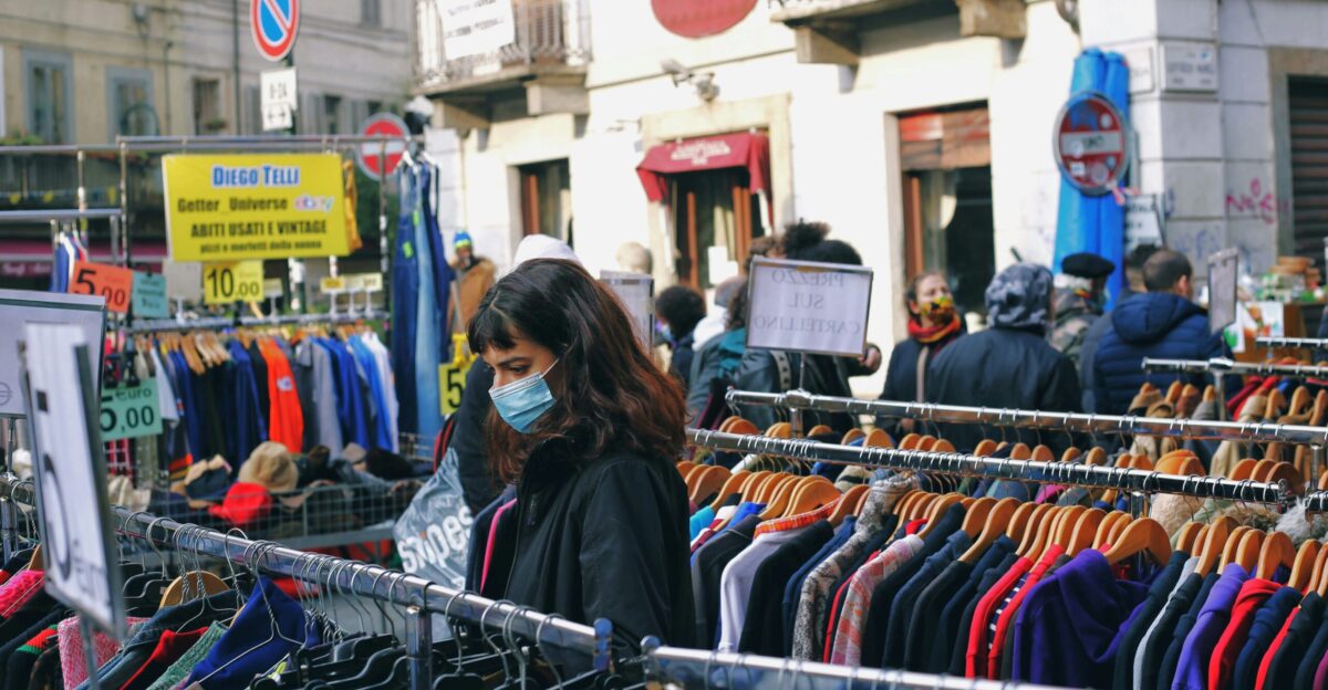 woman in black jacket standing near clothes store during daytime