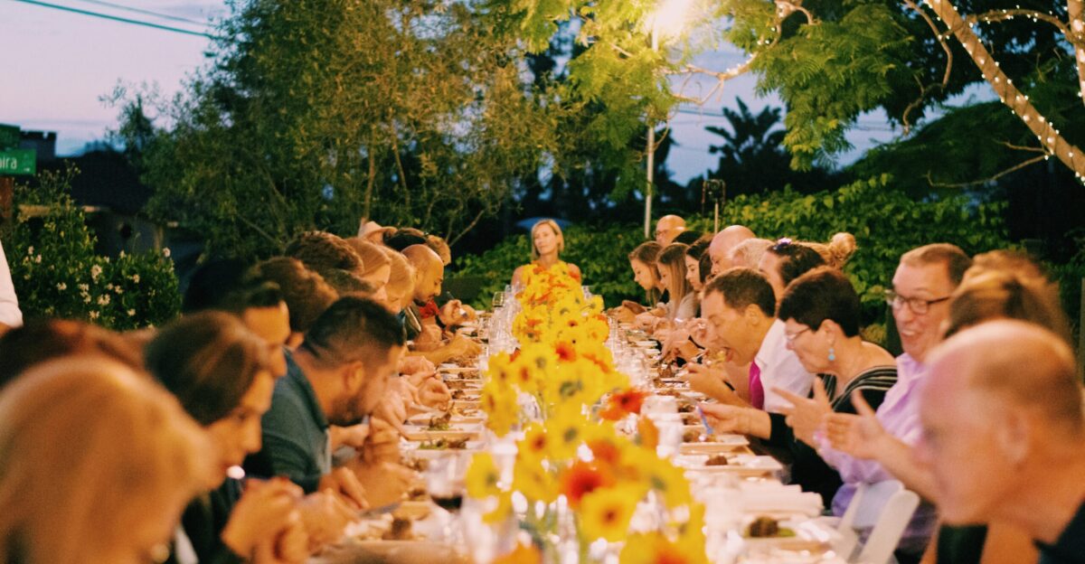 a group of people sitting at a long table