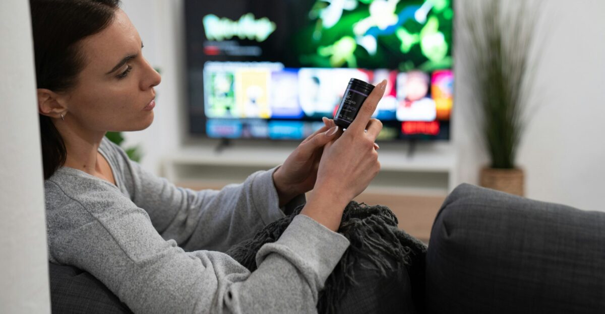 a woman sitting on a couch looking at her cell phone