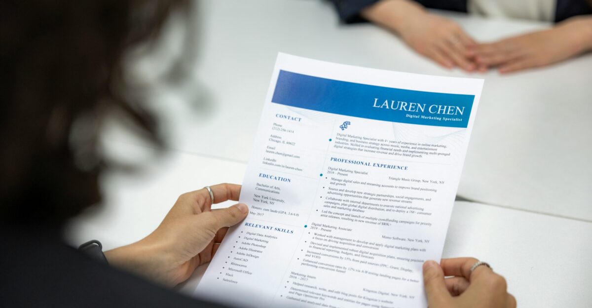 a woman is reading a resume at a table