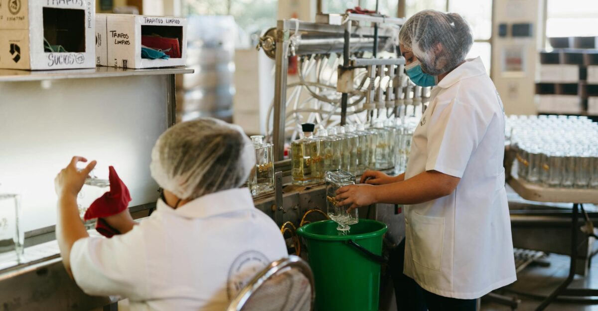 Workers in a tequila factory bottling and cleaning with precision Industrial process